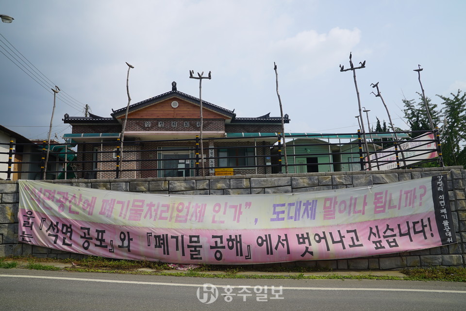 청양군 비봉면 강정리 마을회관 앞에 석면공포와 관련된 현수막이 걸려있다.