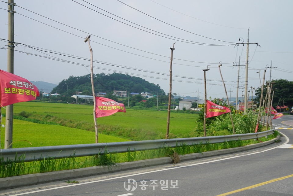 강정마을 도로변 솟대에 걸린 공장폐쇄 요구깃발.