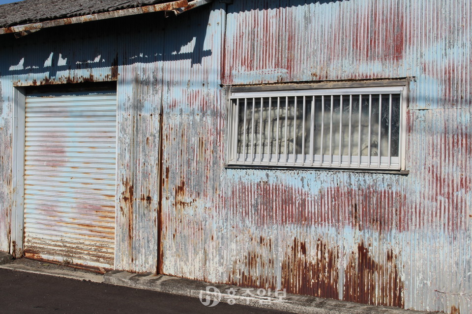 일본 오사카 센난지역의 폐쇄된 석면공장 창틀사이로 석면포대자루가 지금까지 방치돼 있다.
