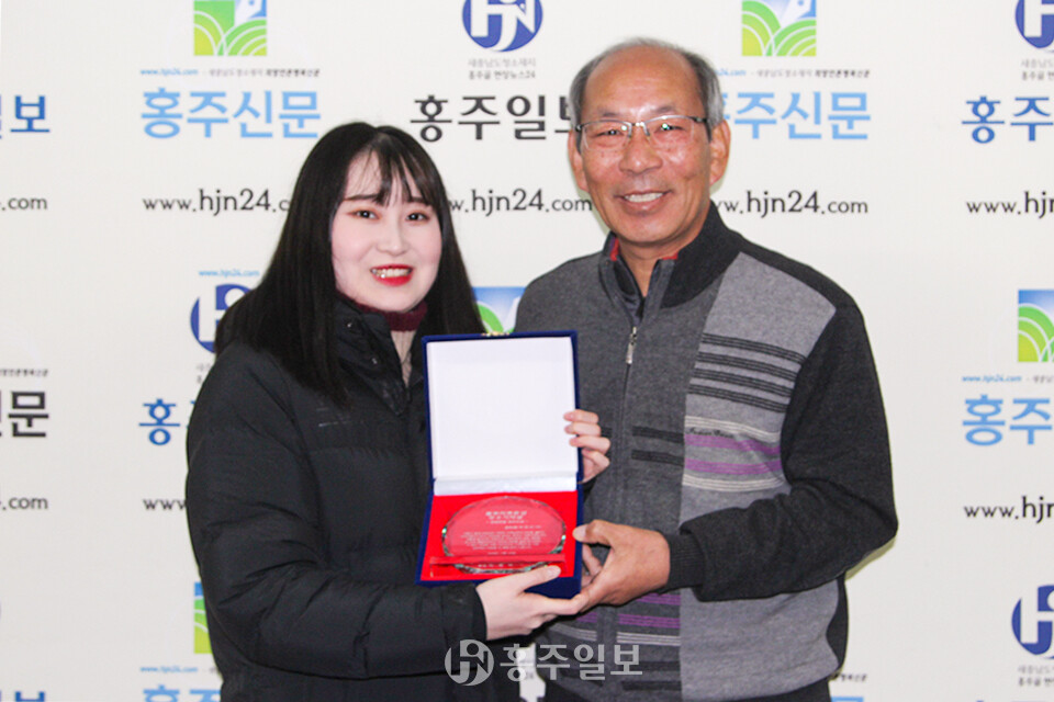 풀뿌리언론상 편집부문 최우수상을 수상한 홍주신문 이정아 기자(사진 왼쪽)가 한관우 대표이사와 기념사진을 촬영하고 있다.