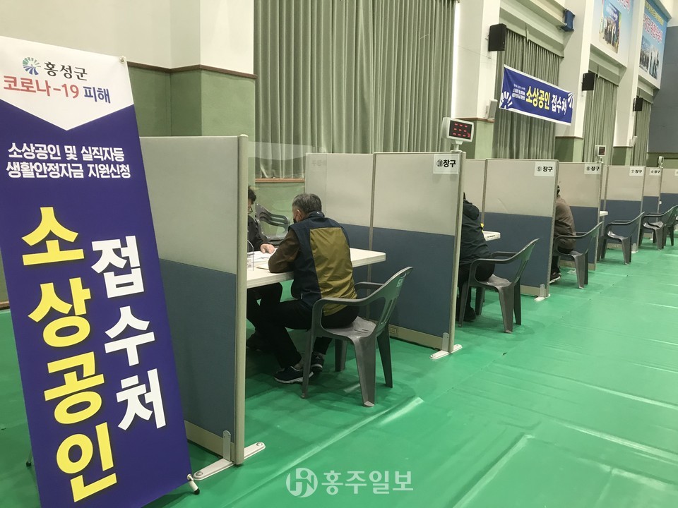 홍성군장애인스포츠센터에 마련된 '긴급생활안정자금' 접수처에서 군청 직원들이  '소상공인' 창구에서 지원 업무를 진행중이다.