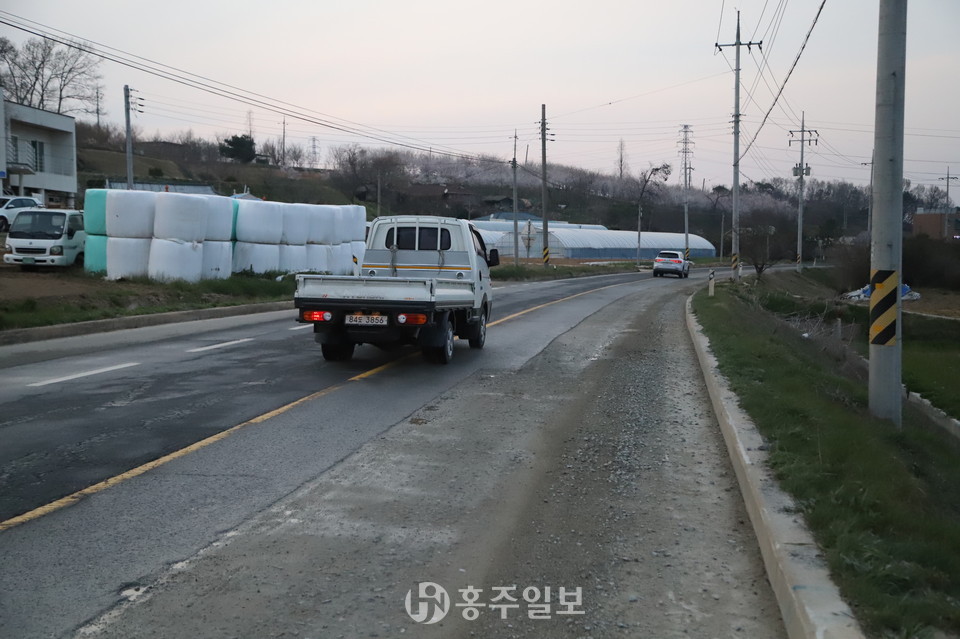 가스관 매설 공사로 아스팔트가 뜯겨나간 비포장 도로면을 피하는 차량들이 어쩔 수 없이 중앙선을 물고 다니고 있다.