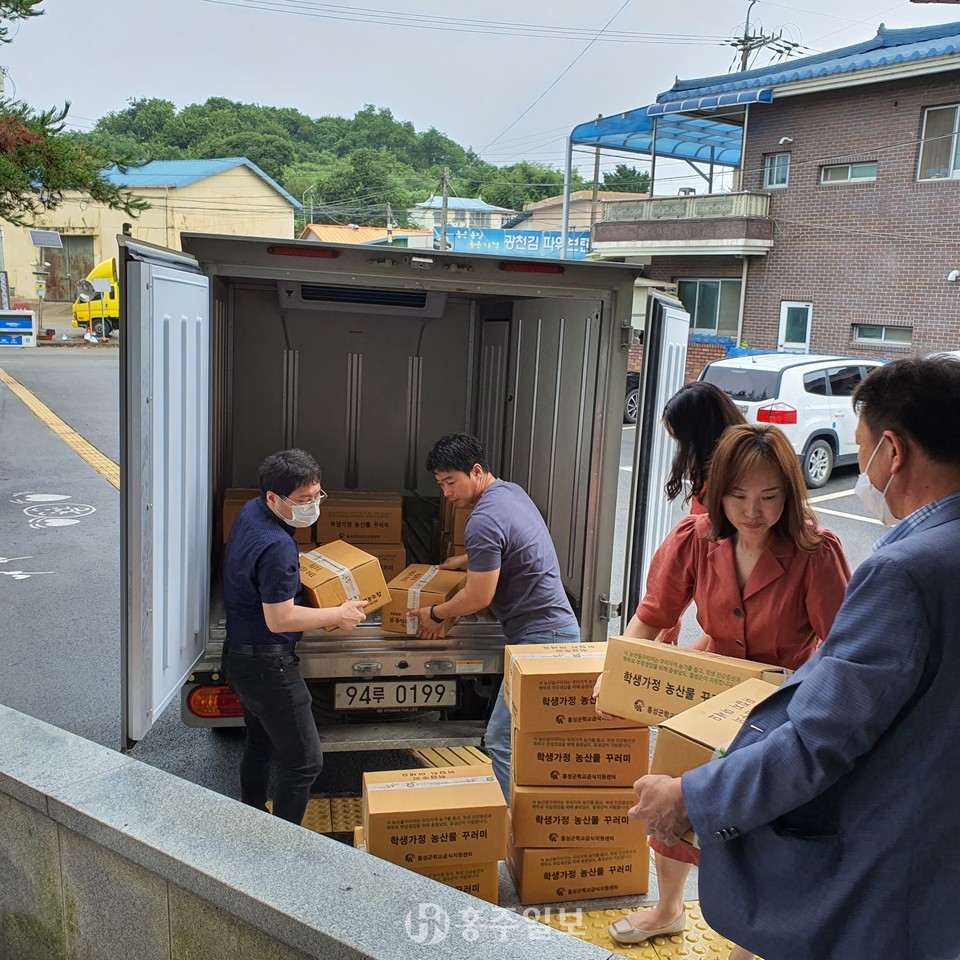 홍성군청소년지원센터 꿈드림 직원들이 학교 밖 청소년들에게 전달할 농산물 꾸러미를 나르고 있다.