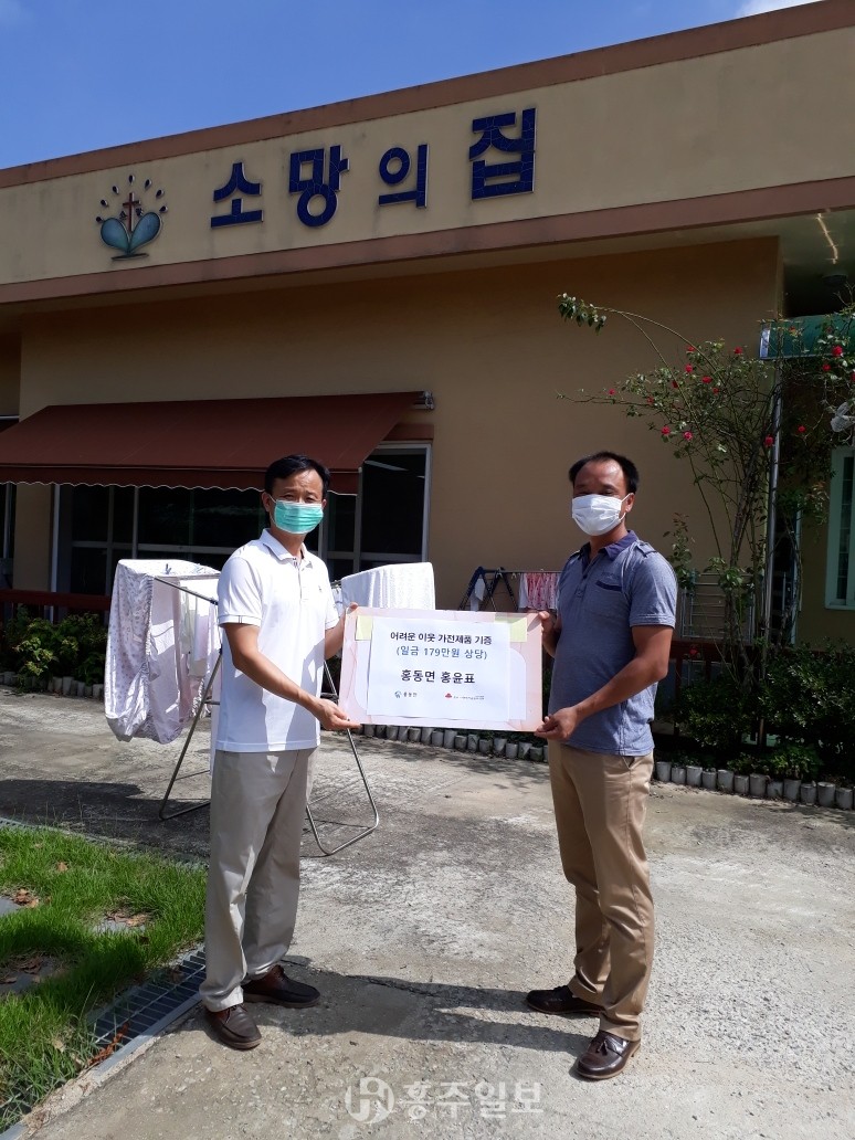 노인복지시설 소망의 집에 본인이 기념행사 경품으로 받은 의류건조기를 기부한 홍동면 거주자 홍윤표 씨(사진 오른쪽).