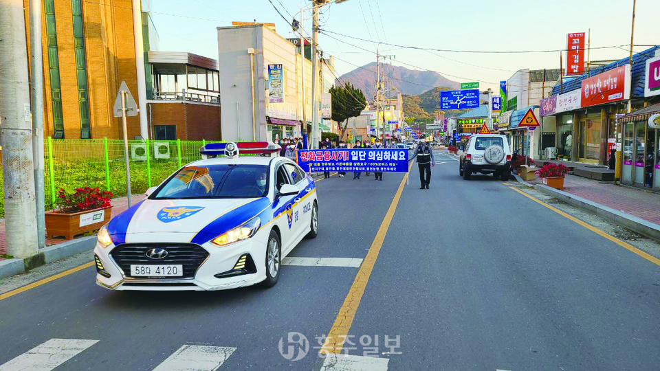 광천오거리를 경찰차와 함께 행진하며 캠페인을 전개하고 있는 홍성경찰서 직원들.