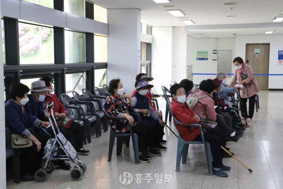 보건인력 점심시간에 건물 밖에 있던 주민들이 관계자의 조치로 대기실에서 기다리고 있다 .