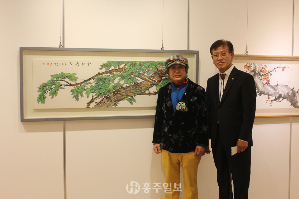 작품 앞에서 포즈를 취하고 있는 임환철 화백(왼쪽)과 유환동 원장(오른쪽).