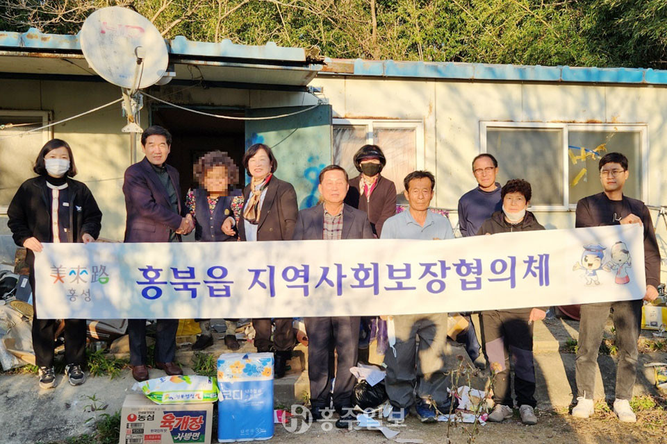 홍북읍지역사회보장협의체가 집수리 사업을 추진하며 기념 촬영을 하고 있다.