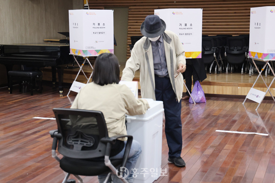 홍성읍 제3투표소에서 한 유권자가 소중한 한 표를 행사하기 위해 투표함에 투표지를 넣고 있다.