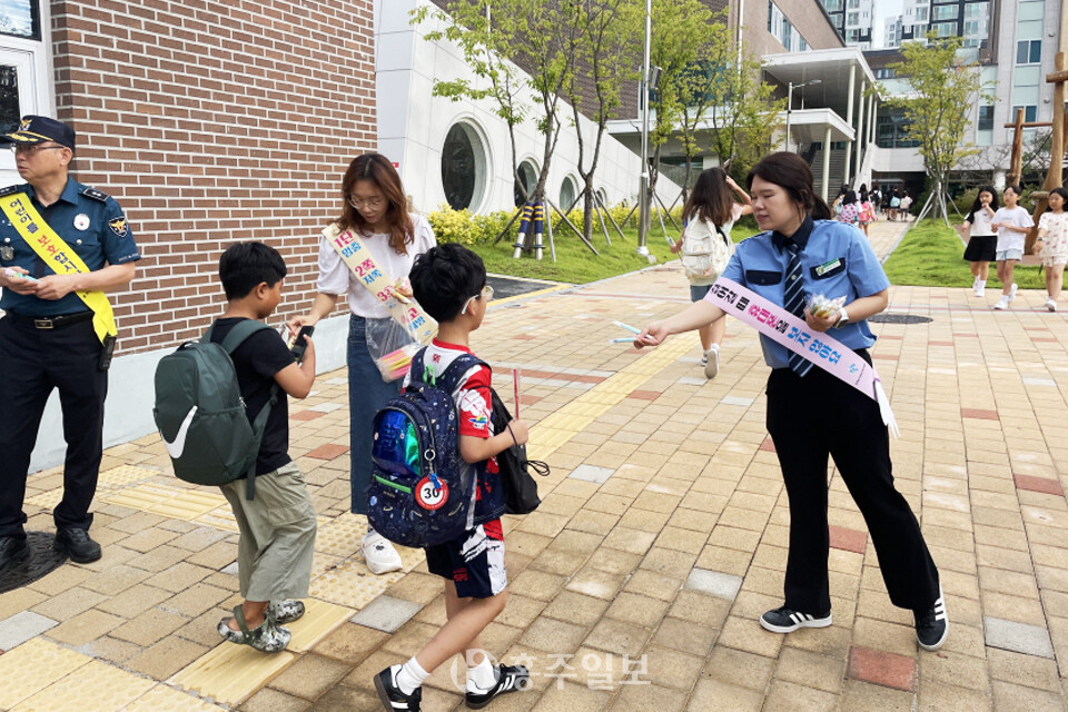 지난 2일 새 학기가 시작된 홍북초등학교 앞에서 등교생을 대상으로 안전한 학교 만들기 캠페인을 진행 중인 모습.