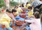 '야생화 및 텃밭상자 전시회'에서 채소묘 화분 만들기 체험 중인 어린이들.
