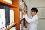 홍성도서관에서 행정보조업무담당 무기계약직으로 근무하게 된 김성민 씨가 도서관에서 책을 정리하고 있다.