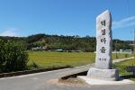 덕정마을 표지석과 마을 전경.