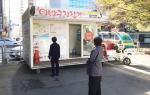 부산역 광장에 있는 이바구자전거와 정류소. 지나가는 행인들이 관심을 갖고 안내판을 바라보고 있다.