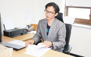 신현창 교수가 연구실 책상에 앉아 작품을 설명하고 있다.