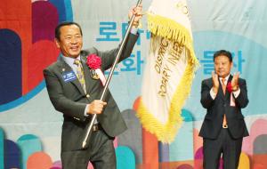 취임식에서 지구기를 인수받아 흔들어보이는 이성엽 취임총재.