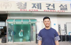 형제건설 이현진 이사가 사무실 앞에서 환하게 웃고 있다.