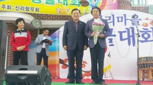 이달순 씨(오른쪽)가 지난 4일 저녁 신리마을 콩쿨대회에서 마을의 문화행사로 정착시킨데 대해 김석환 군수로부터 공로패를 받았다.