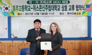 홍주고 구철모 교장과 위스콘신주립대 트레이시 버스 국제처장이 함께 협약서를 들어 보이고 있다.