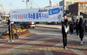 출근하는 직장인들을 대상으로 주소 이전 홍보를 하는 군청 직원들.