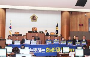더불어민주당 소속 충남도의회 의원들이 도의회 본회의장에서 현수막을 들고 충남인권조례 폐지를 반대하고 있다.