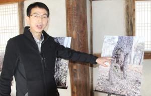 안기억 결성면장이 결성동헌에 전시된 사진을 가리키며 설명하고 있다.