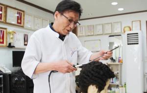 예술로헤어이용원 전영식 대표가 가발을 이용해 실습하고 있다.
