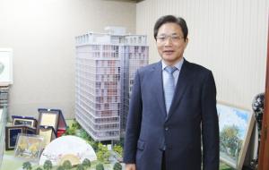 전용주 박사가 자신이 직접 지어 분양한 18층 오피스텔 빌딩 미니어처 앞에서.