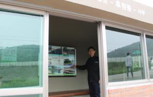 안기억 결성면장이 유지보수공사를 마친 승강장에서 결성관광명소 사진을 가리키고 있다.