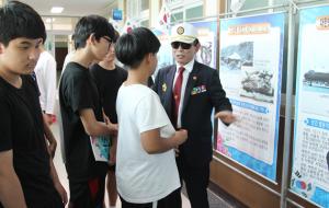 무공수훈자회 최종수 지회장이 홍성중학교 학생들에게 사진에 대해 설명하고 있다.