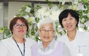 호스피스 병동 직원들이 쉼터에 마련된 소망나무 앞에 모였다.(가운데 모종금 씨)