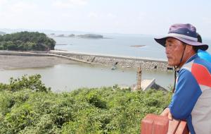 죽도 선착장과 연결된 방파제를 내려다보는 이성준 이장