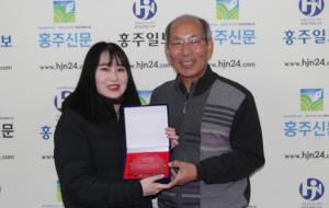 풀뿌리언론상 편집부문 최우수상을 수상한 홍주신문 이정아 기자가 홍주신문 한관우  대표와 기념사진을 촬영하고 있다.