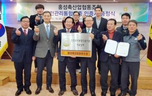 HACCP인증원 관계자와 홍성축협 관계자들이 안전관리통합인증 현판을 들고 기념촬영을 하고 있다.