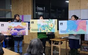 새로 나온 지역화폐를 선보이고 있는 마을 주민들.
