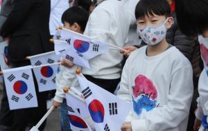 조양문과 제일은행 사거리 일대에 모인 어린이와 주민들이 태극기를 흔들고 있다.