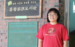 밝맑도서관 앞 김세빈 사서. 최근 소설을 읽고 있어 도서관 이용객에게 소설을 추천한다고 한다.