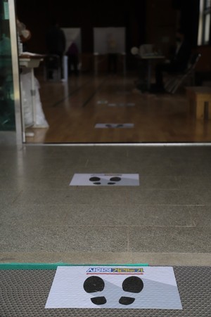 홍동초등학교 홍예관에 마련된 홍동면사전투표소 앞에 '사회적거리두기'를 위해 일정한 간격으로 바닥에 부착해 놓은 안내 문구.