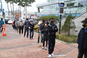 지난 11일 홍성군 광천읍사전투표소가 마련된 광천문예회관에 유권자들이 사전투표하기 위해 길게 줄을 서서 기다리고 있다.