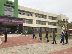등교수업 둘째 날인 지난 21일 홍성여고 학생들이 교사의 안내에 따라 교내 건물로 진입하기 전 2m 간격으로 거리두기를 유지하며 1열로 줄지어 서 있다.