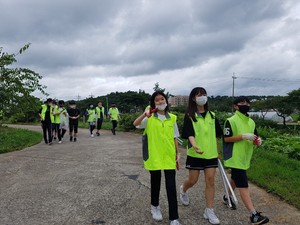 학생들이 홍동천 일원에서 플로깅을 통한 환경 정화 봉사활동을 하고 있다.