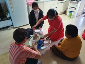 가족봉사단이 홀몸어르신들에게 삼계탕 식사를 대접하고 있다.