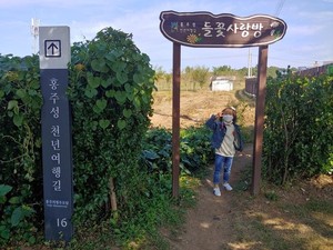 지난 9일 ‘제6회 홍주성천년여행길 걷기행사’에 참여한 한 어린이가 들꽃사랑방 입구에서 사진을 촬영하고 있다.