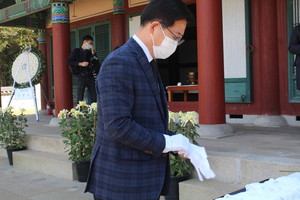 헌화를 하기 전 장갑을 끼고 있는 양승조 충남도 지사.