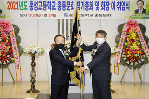 제21대 남기웅 회장(사진 오른쪽)이 제22대 홍일표 회장에게 동문회기를 전달하고 있다.