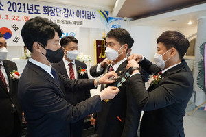 전성수 이임회장이 이상덕 취임회장에게 회장 배지를 전달하고 있다.