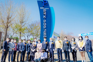 4월 8일 개최된 한국K-POP고등학교 교명 탑 제막식에서 참석자들이 교명 탑을 배경으로 기념사진 촬영을 하고 있다.