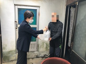 독거 어르신이 반찬을 전달받고 있다.