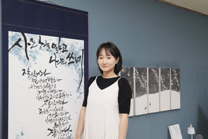 작품들과 함께 포즈를 취한 김예슬 캘리그라퍼.