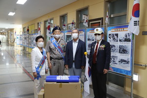 25일 홍성고에 방문한 보훈단체는 이기세 홍성고 교장에게 태극기 국기함 세트 50개를 전달했다.